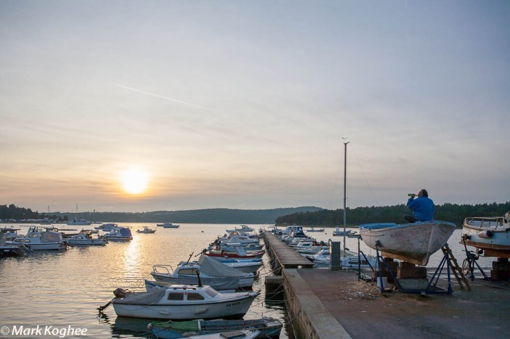 On December 22 a man drinks a beer while he works on his boat in the deserted Croatian village of Medulin.